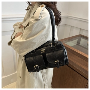 Detail of vintage black shoulder bag featuring double front flap pockets and gold hardware