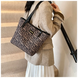 Dettaglio della borsa tote leopardata con spalline nere e etichetta alla moda