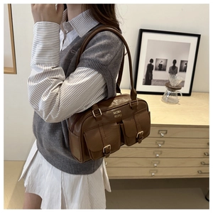 Detail of vintage brown bowling bag featuring textured leather and two front pockets