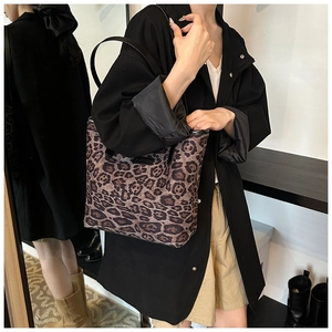 Borsa tote leopardata indossata dalla modella con spalline nere e etichetta fashion