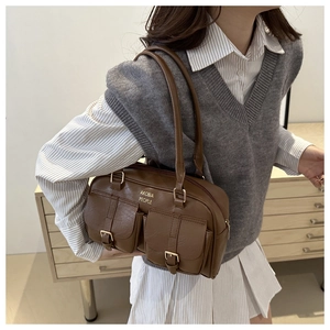 Close-up of vintage brown bowling bag featuring double front pockets and gold metal buckles