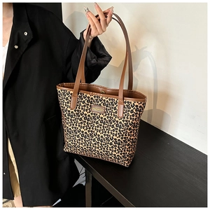 Dettaglio della borsa tote leopardata con etichetta moda e manici marroni eleganti