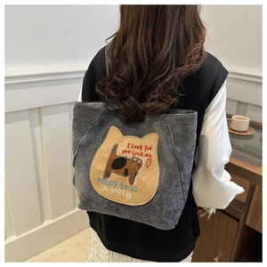 Detail of grey fabric tote bag featuring cute cat patchwork embroidery and side zippers