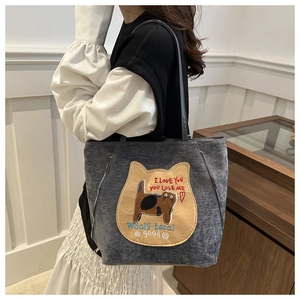 Detail of grey canvas tote bag featuring cute cat patchwork embroidery and side zippers