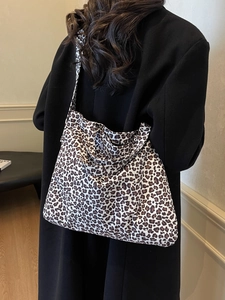 Sac fourre-tout en toile imprimé léopard porté à l'épaule pour un style chic