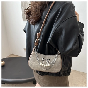 Détail du sac demi-lune vintage gris avec nœud papillon argenté et chaîne de perles