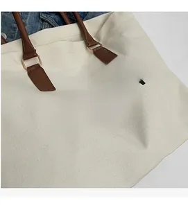 Detailed close-up of canvas tote bag with leather handles and Fashion Paris print
