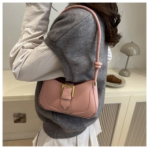 Gros plan détaillé d'un sac demi-lune rose avec boucle dorée et bandoulière à nœuds
