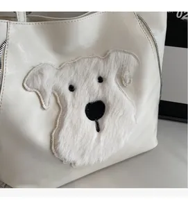 Detail of white tote bag featuring a cute plush dog patch and smooth PU leather texture