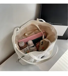 Top view of large white leather tote bag interior showing capacity for tablet and umbrella