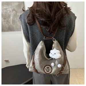 Détail du sac cabas en toile avec logo M, bandoulière chaîne et gris-gris nuage