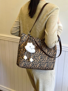 Chic leopard print tote bag with brown leather straps and cute plush cloud charm