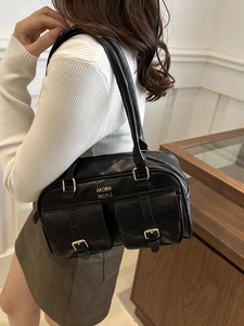 Vintage black faux leather bowling shoulder bag with dual front pockets and gold hardware