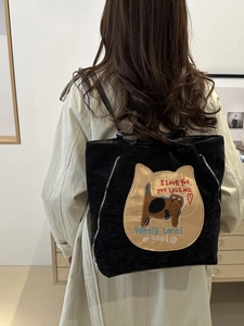 Cute black cat embroidered large tote bag shown on model in cozy interior setting