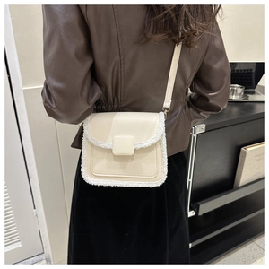 Détail du sac bandoulière crème avec bordure en fausse fourrure et lanière en cuir