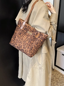 Borsa tote leopardata con cinturini marroni indossata da una modella in trench