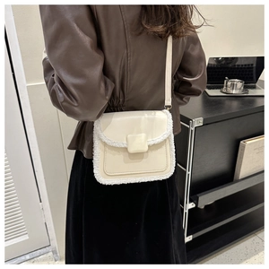 Détail du sac à bandoulière en cuir crème avec bordure en fausse fourrure blanche