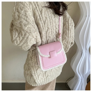 Détail du petit sac rose avec bordure en laine blanche et boucle en cuir élégante