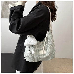 Detail of mint green jacquard tote bag with white strap and cute cloud plush charm