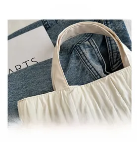 Close-up of pleated nylon tote bag texture with smooth handle and artsy background