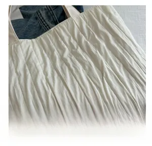Detailed macro view of white vertical pleated fabric texture on a commuter tote bag