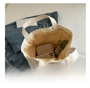 Detailed view of white quilted tote bag interior with magnetic snap and spacious storage