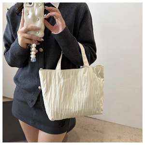 Detail of white pleated tote bag showing the vertical texture and soft nylon fabric