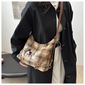 Detail of vintage yellow-brown plaid crossbody bag with cute puppy print and metal rings