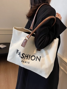 Minimalist off-white canvas tote bag with brown leather straps and black fashion print
