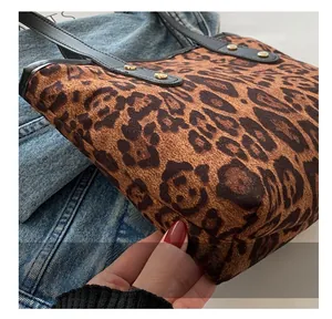 Dettaglio borsa shopper leopardata con texture morbida e rivetti dorati sul cinturino