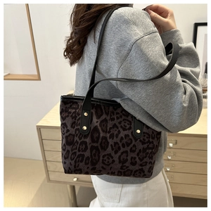 Dettaglio della borsa tote leopardata con manici in finta pelle nera e rivetti dorati fini