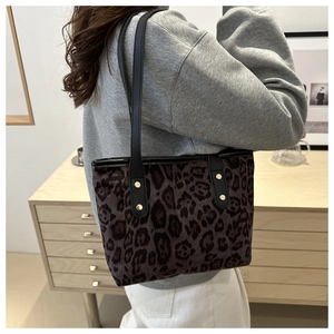 Dettaglio borsa tote leopardata con fibbie dorate indossata da una modella in stile minimal