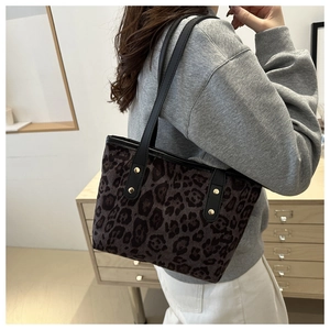 Dettagli della borsa tote leopardata con borchie dorate e tracolla nera elegante