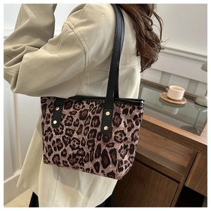 Dettaglio della borsa tote leopardata con manici neri e rivetti dorati decorativi