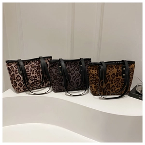 Tre borse tote con stampa leopardata nei toni del marrone e grigio su scale bianche