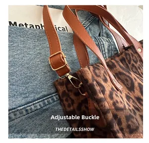Detail of adjustable leather strap with gold buckle on leopard print tote bag