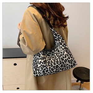 Detail of large black and white leopard print tote bag with wide black shoulder strap