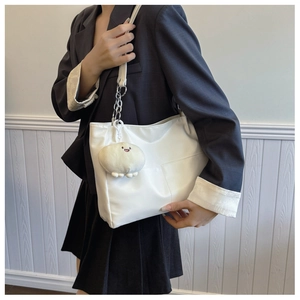 White faux leather tote bag with crisscross stitching and cute plush animal charm detail