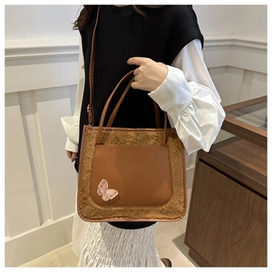 Détail du sac fourre-tout marron avec papillon à paillettes et bordure en peluche