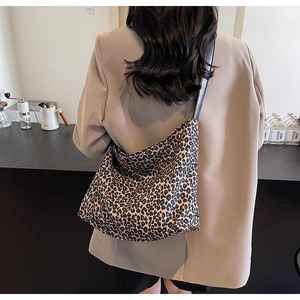Sac hobo léopard avec bandoulière noire porté par un mannequin dans un style décontracté