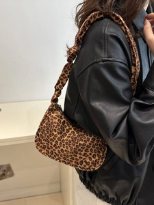Sac hobo tendance à imprimé léopard avec bandoulière large porté sur une veste en cuir