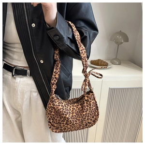 Detail of leopard print moon bag featuring a fabric texture and decorative bow knot