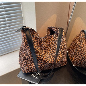 Détail du sac cabas léopard avec fines bandoulières en cuir noir et boucle en métal