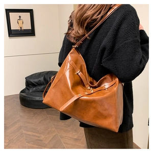 Detail of a large vintage brown hobo shoulder bag with crossbody strap and buckle