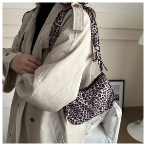Chic leopard print underarm bag shown on a model with a stylish beige trench coat