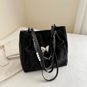 Detail of black metallic tote bag with silver butterfly charm and pearl metal chain