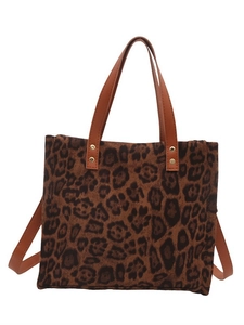 Leopard print tote bag with brown leather handles and gold studs on white background