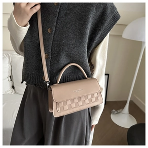 Detail of beige square handbag with woven texture and Fashion Trend logo and strap