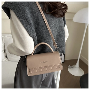 Detail showing checkered weave texture and brand logo on beige crossbody handbag