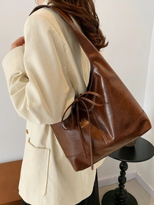 Retro deep brown tote bag with bow detail on beige corduroy blazer for a chic look